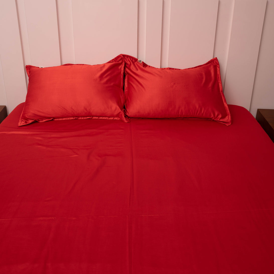 Ruby red satin bedsheet with matching pillowcases close-up