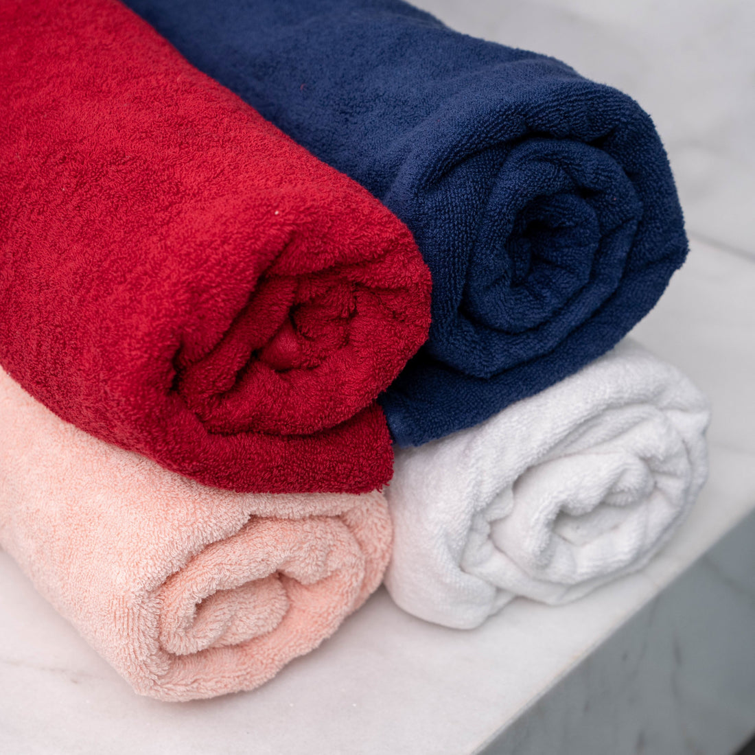 100% cotton towels in red, navy, white, rose folded — BedCheats Egypt