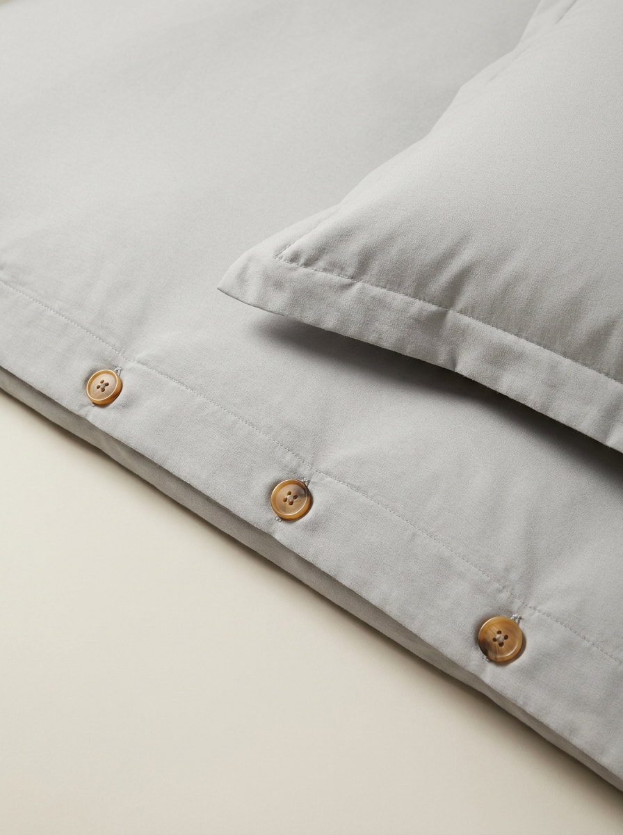 Light gray duvet cover button closure close-up