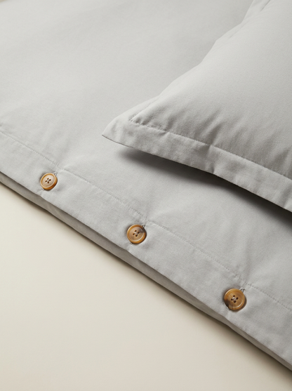 Light gray duvet cover button closure close-up